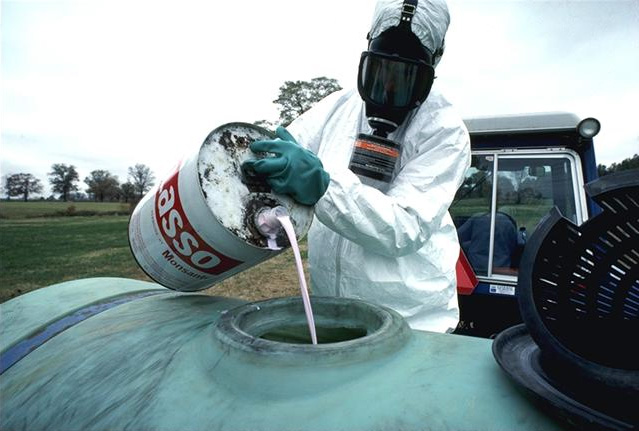 Farmer pouring pesticide into sprayer tank